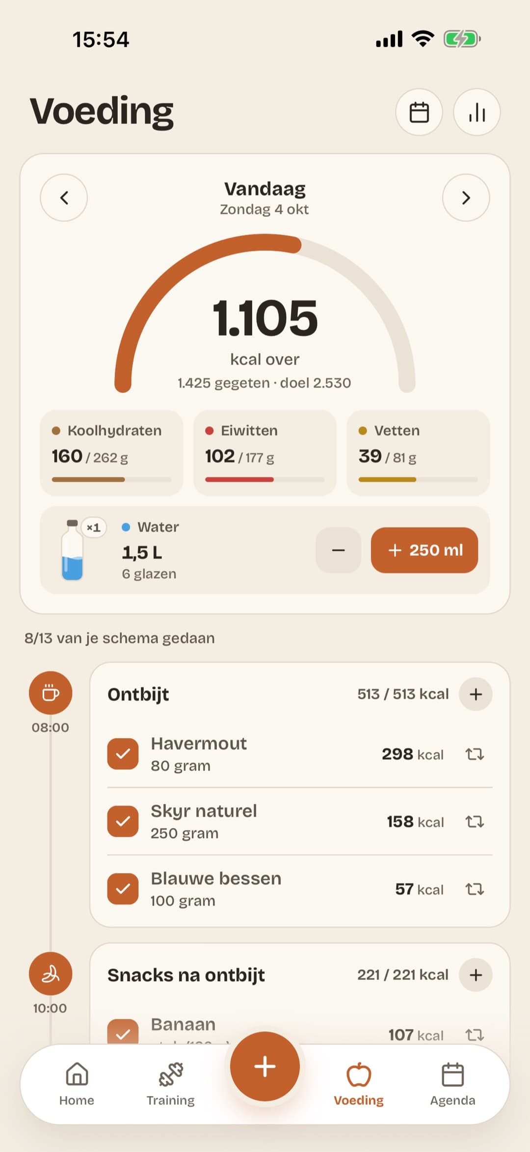 Het voedingsscherm: de calorieën die je vandaag nog over hebt, de koolhydraten, eiwitten en vetten tegenover je doel, je water, en daaronder het voedingsschema van je coach per maaltijd om af te vinken.